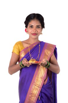 Indian woman performing worship, portrait of a beautiful young lady with pooja thali isolated on white background