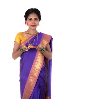 Indian woman performing worship, portrait of a beautiful young lady with pooja thali isolated on white background