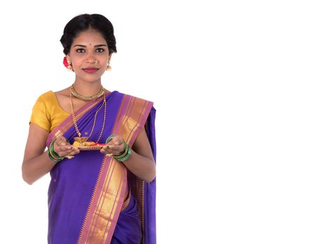 Indian woman performing worship, portrait of a beautiful young lady with pooja thali isolated on white background