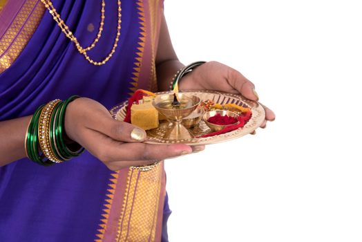 Indian woman performing worship, portrait of a beautiful young lady with pooja thali isolated on white background