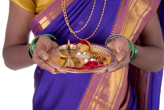 Indian woman performing worship, portrait of a beautiful young lady with pooja thali isolated on white background