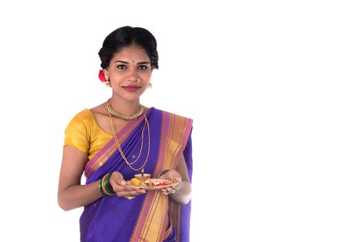 Indian woman performing worship, portrait of a beautiful young lady with pooja thali isolated on white background