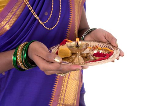 Indian woman performing worship, portrait of a beautiful young lady with pooja thali isolated on white background