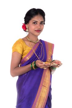 Indian woman performing worship, portrait of a beautiful young lady with pooja thali isolated on white background