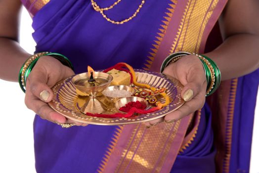 Indian woman performing worship, portrait of a beautiful young lady with pooja thali isolated on white background