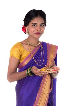 Indian woman performing worship, portrait of a beautiful young lady with pooja thali isolated on white background