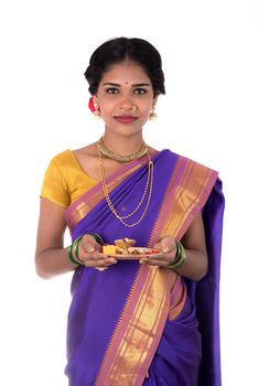 Indian woman performing worship, portrait of a beautiful young lady with pooja thali isolated on white background