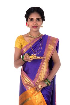 Indian woman performing worship, portrait of a beautiful young lady with pooja thali isolated on white background