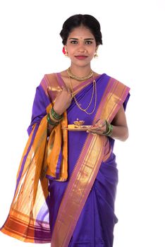 Indian woman performing worship, portrait of a beautiful young lady with pooja thali isolated on white background