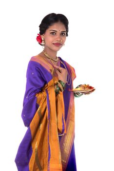 Indian woman performing worship, portrait of a beautiful young lady with pooja thali isolated on white background