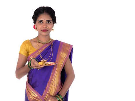 Indian woman performing worship, portrait of a beautiful young lady with pooja thali isolated on white background