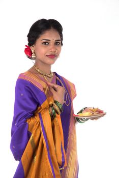 Indian woman performing worship, portrait of a beautiful young lady with pooja thali isolated on white background