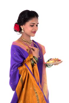 Indian woman performing worship, portrait of a beautiful young lady with pooja thali isolated on white background