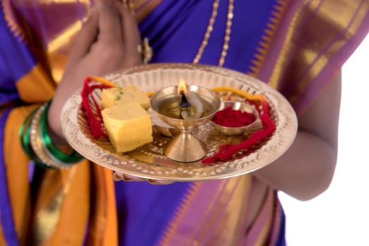 Indian woman performing worship, portrait of a beautiful young lady with pooja thali isolated on white background