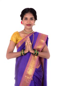 Young Indian girl in traditional clothing greeting namaste, Welcome, Indian girl in a tradition sari with welcome expression (inviting)