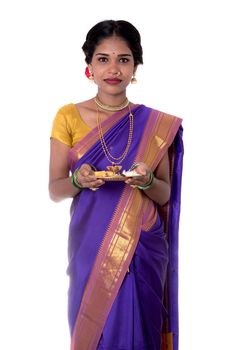 Indian woman performing worship, portrait of a beautiful young lady with pooja thali isolated on white background