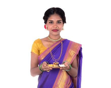 Indian woman performing worship, portrait of a beautiful young lady with pooja thali isolated on white background