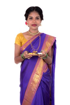 Indian woman performing worship, portrait of a beautiful young lady with pooja thali isolated on white background