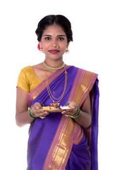 Indian woman performing worship, portrait of a beautiful young lady with pooja thali isolated on white background