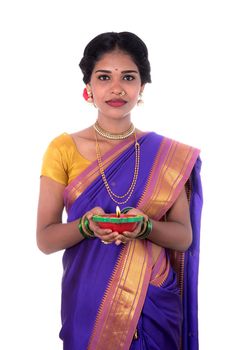 Portrait of a woman holding diya, Diwali or deepavali photo with female hands holding oil lamp during festival of light on white background