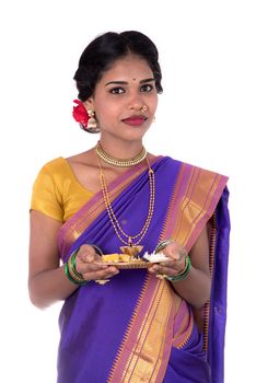 Indian woman performing worship, portrait of a beautiful young lady with pooja thali isolated on white background