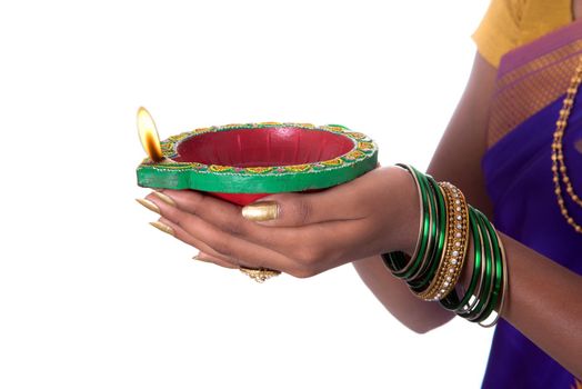 Portrait of a woman holding diya, Diwali or deepavali photo with female hands holding oil lamp during festival of light on white background