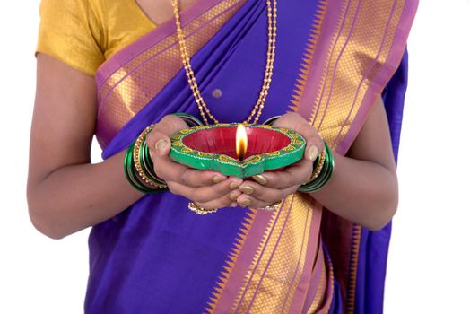 Portrait of a woman holding diya, Diwali or deepavali photo with female hands holding oil lamp during festival of light on white background