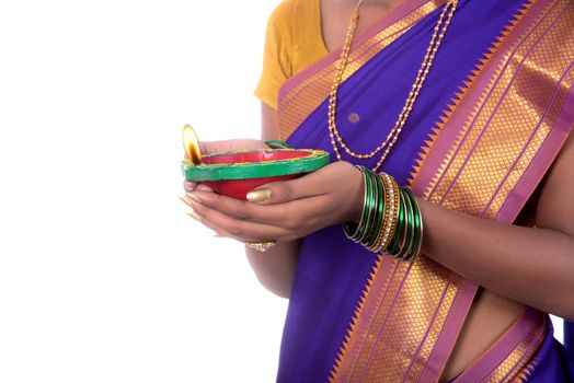 Portrait of a woman holding diya, Diwali or deepavali photo with female hands holding oil lamp during festival of light on white background