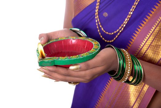 Portrait of a woman holding diya, Diwali or deepavali photo with female hands holding oil lamp during festival of light on white background