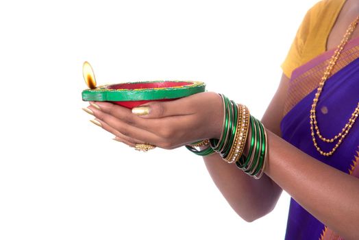 Portrait of a woman holding diya, Diwali or deepavali photo with female hands holding oil lamp during festival of light on white background