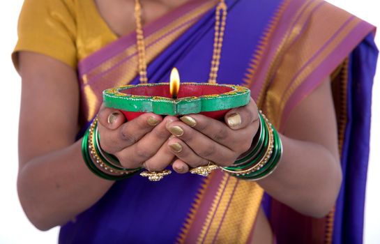 Portrait of a woman holding diya, Diwali or deepavali photo with female hands holding oil lamp during festival of light on white background