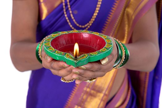 Portrait of a woman holding diya, Diwali or deepavali photo with female hands holding oil lamp during festival of light on white background