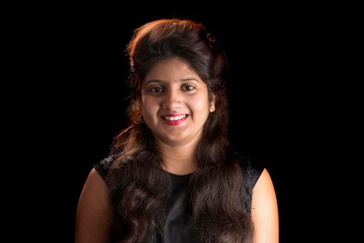 Portrait of beautiful young girl on black background