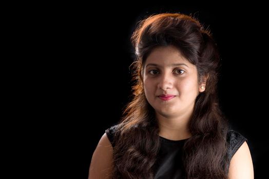 Portrait of beautiful young girl on black background