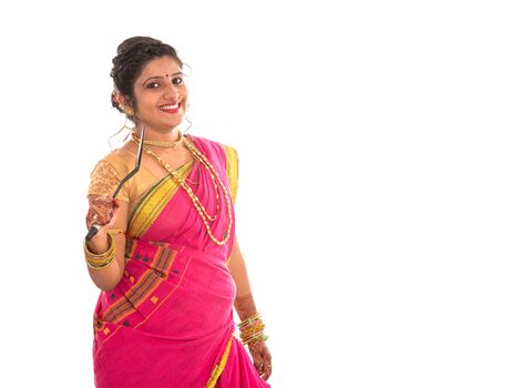 Young Traditional Indian Girl holding kitchen utensil on white background