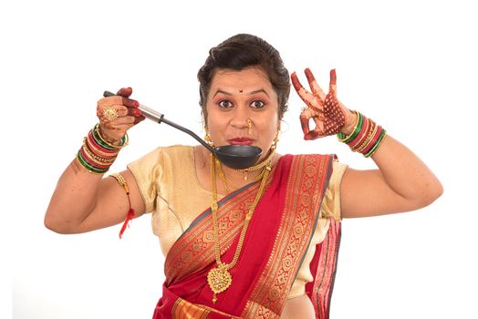 Young Traditional Indian Girl holding kitchen utensil on white background