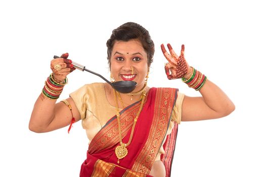 Young Traditional Indian Girl holding kitchen utensil on white background