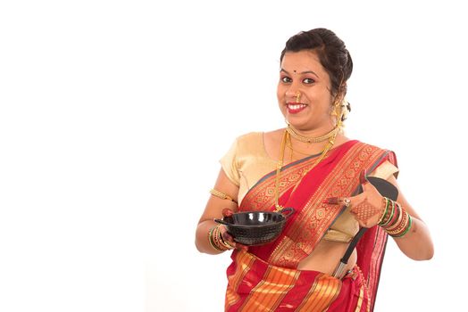 Young Traditional Indian Girl holding kitchen utensil on white background