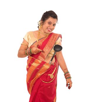 Young Traditional Indian Girl holding kitchen utensil on white background