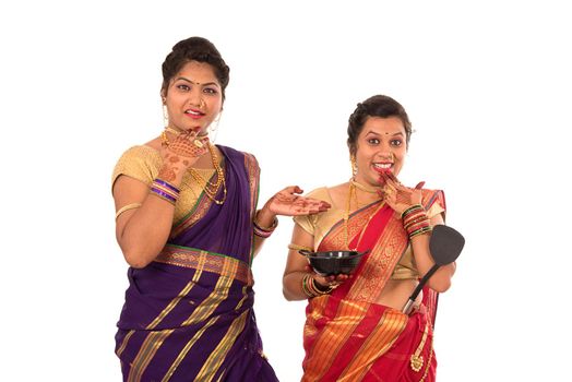 Young Traditional Indian Girls holding kitchen utensil on white background