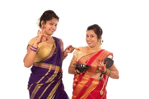 Young Traditional Indian Girls holding kitchen utensil on white background