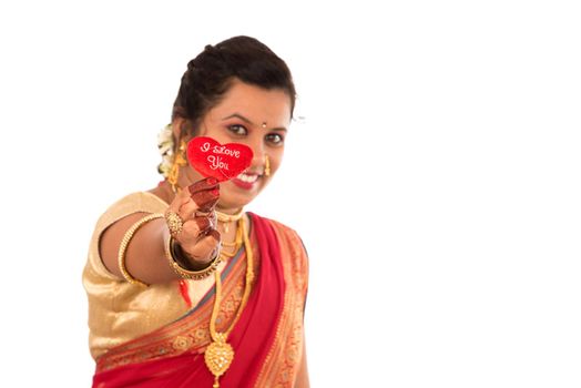 Traditional Beautiful Indian young girl in saree posing with Heart on white background