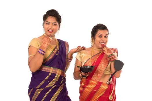 Young Traditional Indian Girls holding kitchen utensil on white background