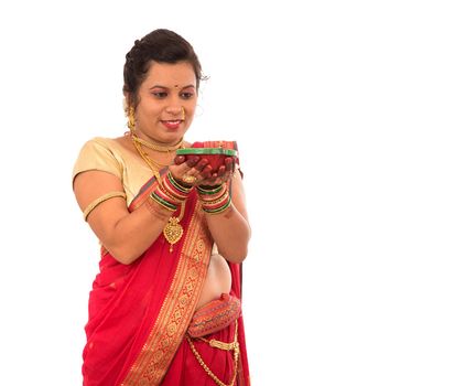 Portrait of a Indian Traditional Girl holding pooja thali with diya during festival of light on white background. Diwali or deepavali