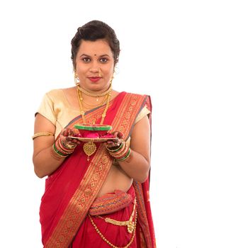 Portrait of a Indian Traditional Girl holding pooja thali with diya during festival of light on white background. Diwali or deepavali