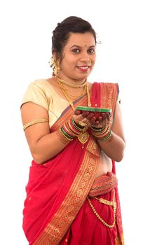 Portrait of a Indian Traditional Girl holding pooja thali with diya during festival of light on white background. Diwali or deepavali