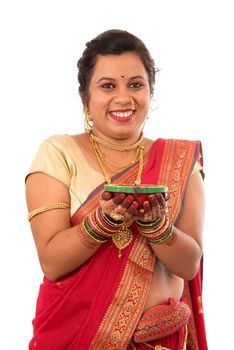 Portrait of a Indian Traditional Girl holding pooja thali with diya during festival of light on white background. Diwali or deepavali