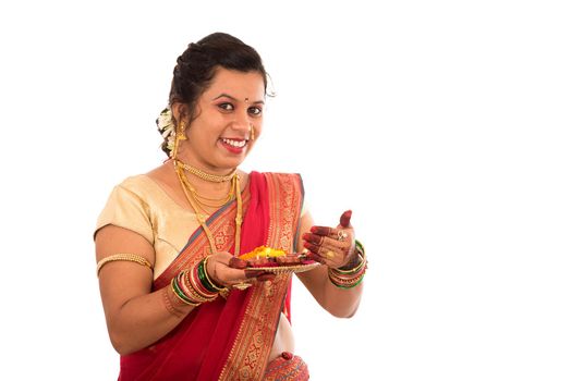 Portrait of a Indian Traditional Girl holding pooja thali with diya during festival of light on white background. Diwali or deepavali