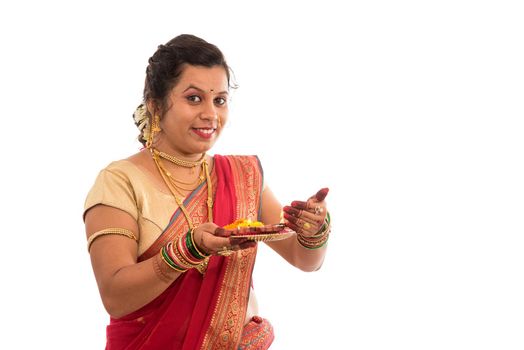 Portrait of a Indian Traditional Girl holding pooja thali with diya during festival of light on white background. Diwali or deepavali