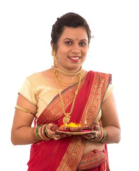 Portrait of a Indian Traditional Girl holding pooja thali with diya during festival of light on white background. Diwali or deepavali